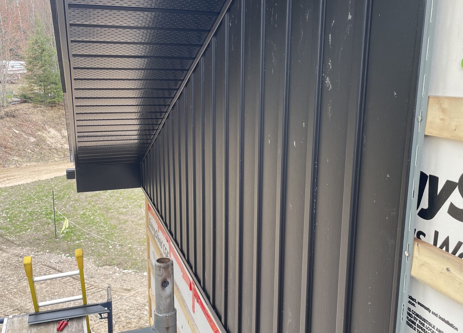Completed black board-and-batten exterior with crisp soffit detailing.