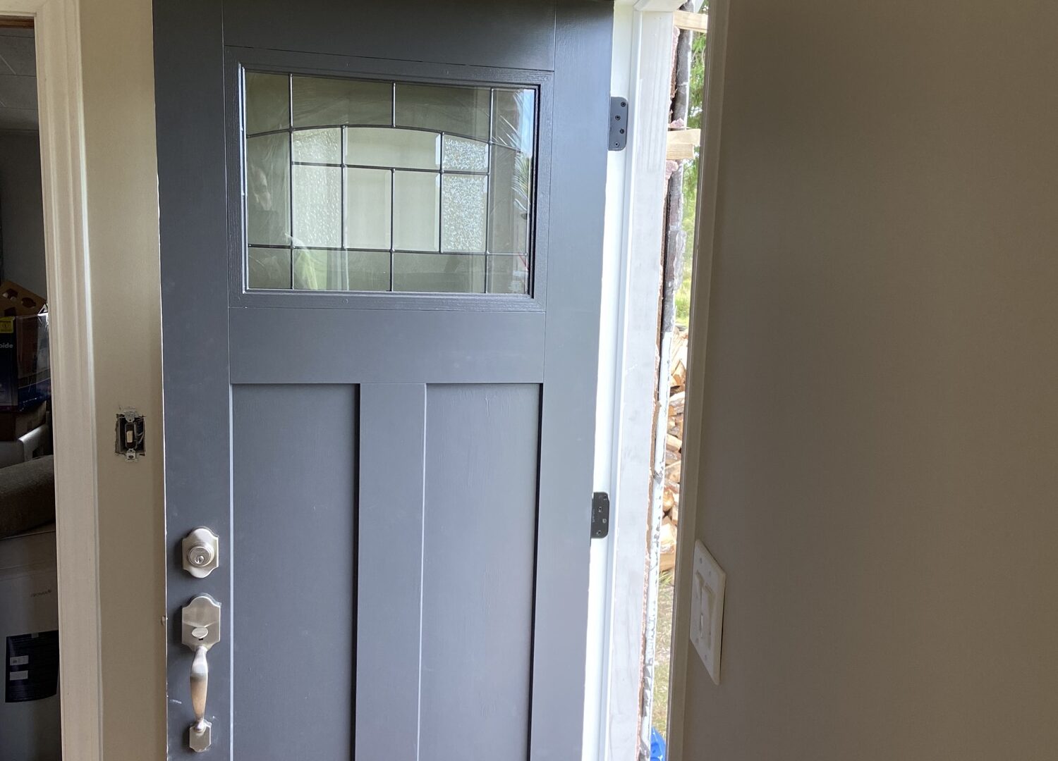 Finished modern-farmhouse room with craftsman grey entry door, whitewashed plank ceiling and wood-look floors in Mattawa, Ontario.