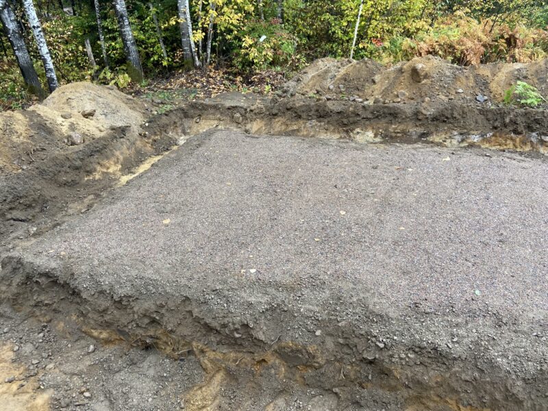 Excavated building pad with a compacted gravel base ready for foundation work