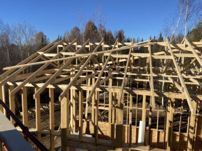 Roof rafters and trusses framed over the garage against a blue sky
