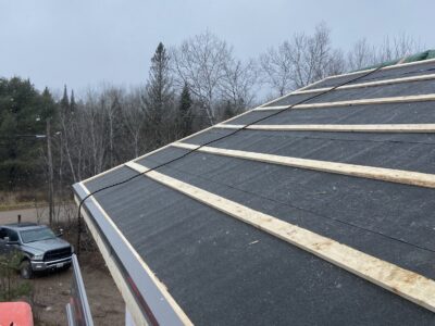 Roof slope with underlayment, wood strapping, and a metal drip edge