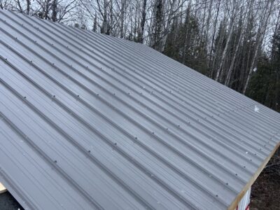 Completed grey ribbed steel roof on the garage