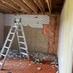 Interior taken back to ceiling joists and studs with the old brick wall removed and insulation exposed