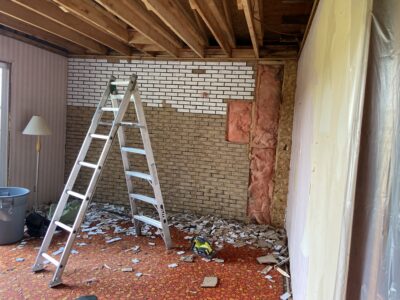 Interior taken back to ceiling joists and studs with the old brick wall removed and insulation exposed