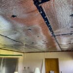 Ceiling fitted with reflective foil radiant-barrier insulation between taped seams
