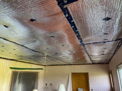 Ceiling fitted with reflective foil radiant-barrier insulation between taped seams