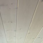 Close-up of a whitewashed tongue-and-groove wood plank ceiling