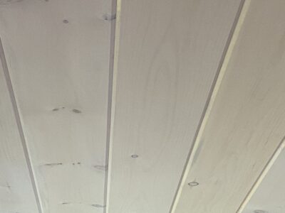 Close-up of a whitewashed tongue-and-groove wood plank ceiling