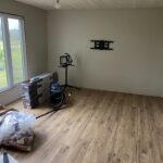 Room with new wood-look plank flooring installed and boxes of flooring staged