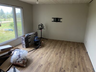 Room with new wood-look plank flooring installed and boxes of flooring staged