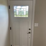 Interior view of a new white craftsman entry door with decorative leaded glass